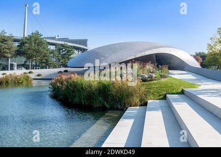 Il padiglione aerodinamico con tetto in acciaio ricurlato per Porsche all'Autostadt - città dell'automobile - a Wolfsburg, progettato dagli architetti tedeschi HENN. Foto Stock