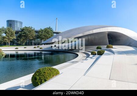 Il padiglione aerodinamico con tetto in acciaio ricurlato per Porsche all'Autostadt - città dell'automobile - a Wolfsburg, progettato dagli architetti tedeschi HENN. Foto Stock