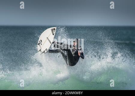 Un surfista che si dilata a Fistral a Newquay in Cornovaglia. Foto Stock