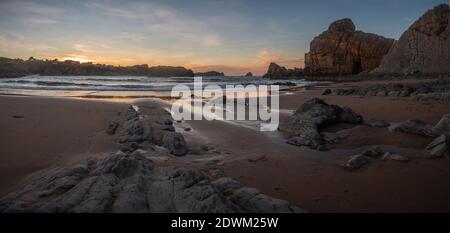 Splendida vista panoramica sulla spiaggia di Portio al tramonto a Liencres, Cantabria. Foto Stock