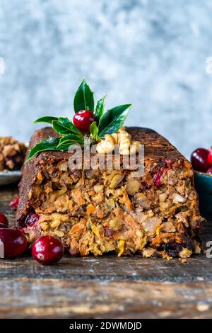 Filone di noce arrosto vegano con mirtilli rossi su tavolo di legno Foto Stock