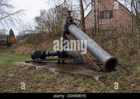 Vecchia pompa che pompa acqua piovana in una foresta a Stekene, Belgio Foto Stock