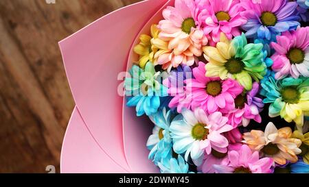 Primo piano fiori fiori arcobaleno fiori bouquet luminoso su sfondo di legno Foto Stock