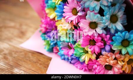 Primo piano fiori fiori arcobaleno fiori bouquet luminoso su sfondo di legno Foto Stock