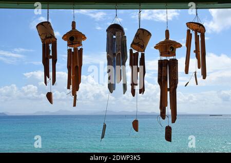 Vento Chimes contro il cielo blu con nuvole e mare. Foto Stock