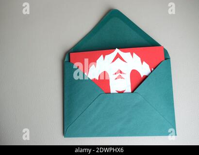 Cartolina di Natale fatta a mano in busta verde. Foto Stock
