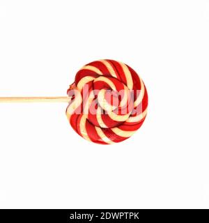 Un lollipop rosso e bianco vorticoso isolato su un bianco sfondo Foto Stock