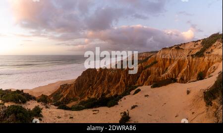 Molte bizzarre dune di sabbia erose sull'Oceano Atlantico con onde che si infrangono al tramonto Foto Stock