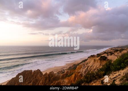 Molte bizzarre dune di sabbia erose sull'Oceano Atlantico con onde che si infrangono al tramonto Foto Stock