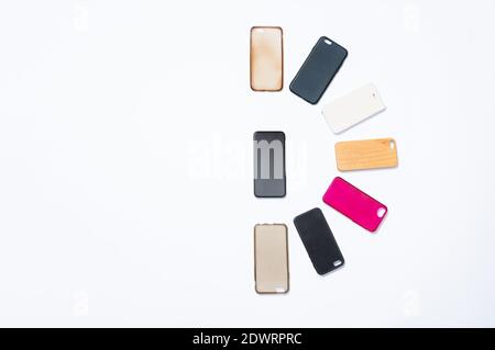 Pila di cover posteriori in plastica multicolore per cellulare su sfondo bianco. Scelta di accessori per la protezione dello smartphone. Un sacco di silicone telefono ba Foto Stock