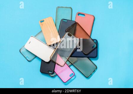 Pila di plastica multicolore torna copertine per i telefoni cellulari su sfondo blu Foto Stock