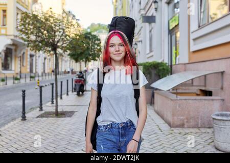 Alla moda creativo ragazza musicista adolescente con chitarra in caso di camminare lungo la città Foto Stock