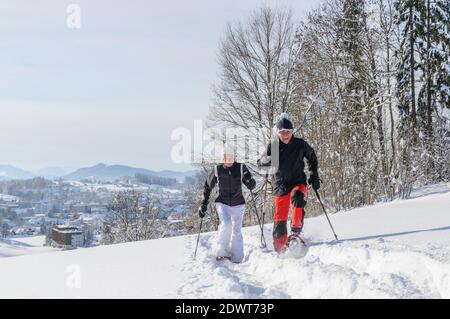 Coppia anziana che cammina nella natura con le racchette da neve Foto Stock