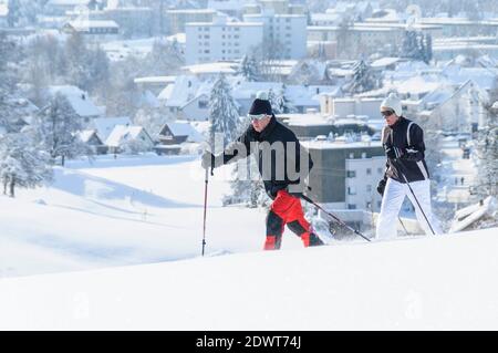 Coppia anziana che cammina nella natura con le racchette da neve Foto Stock