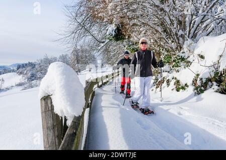 Coppia anziana che cammina nella natura con le racchette da neve Foto Stock