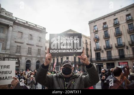 Barcellona, Spagna. 23 dicembre 2020. Il manifestante ha tenuto un cartello che dice, 'giochi pubblici sì, giochi privati no, contro la discriminazione', durante la manifestazione. I lavoratori del Bingo e Casino di Catalogna protestano per l'unica attività economica diurna che rimane chiusa a causa delle restrizioni della pandemia. Credit: SOPA Images Limited/Alamy Live News Foto Stock