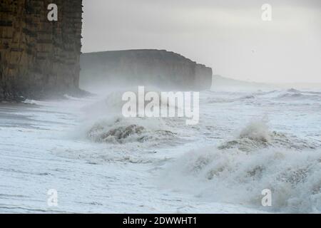 West Bay, Dorset, Regno Unito. 23 dicembre 2020. Regno Unito Meteo. I mari tempestosi si schiantano a riva sulla spiaggia di West Bay a Dorset in un pomeriggio di pioggia e forti venti raffinate. Picture Credit: Graham Hunt/Alamy Live News Foto Stock