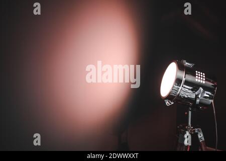 Lampada da faretto rosso luminoso su una parete scura con spazio per la copia Foto Stock