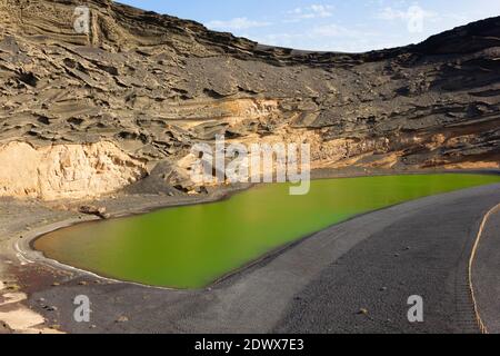 Famoso Lago Verde circondato da formazioni rocciose vulcaniche a El Golfo, Lanzarote. Iconico punto di riferimento naturale nelle isole Canarie. Concetto di destinazione del viaggio Foto Stock