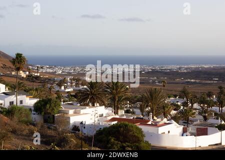 Città di Nazaret al tramonto con case bianche e oceano sullo sfondo. Piccolo villaggio sull'isola di Lanzarote, Spagna. Turismo, concetti immobiliari Foto Stock