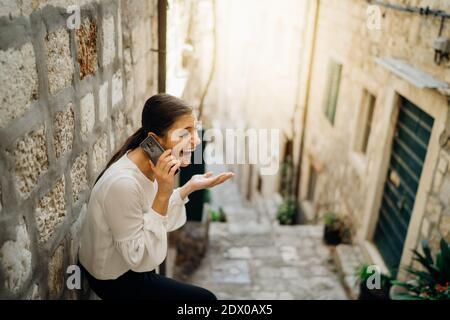 Donna ridente eccitato che ha una chiamata di chat meeting.Using un sociale Piattaforma di rete per rimanere connessi.tecnologia app per smartphone per comunicazioni via Internet Foto Stock