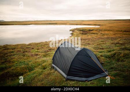 Impostazione di Tent.Camping all'esterno su un bel prato vicino al lake.Road viaggio campeggio in Islanda.Morning scene.Sleeping in Tents.Hikers alloggio per th Foto Stock