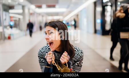 Emozionato shopper donna tenuta ha comprato gli articoli in colorful bags.Customer in un centro commerciale, prezzi di sconto shopping craze.Woman addicted a shopping b Foto Stock