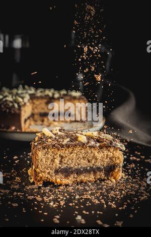 Torta di cioccolato dolce. Torta con spruzzette di cioccolato su tavola nera. Foto Stock