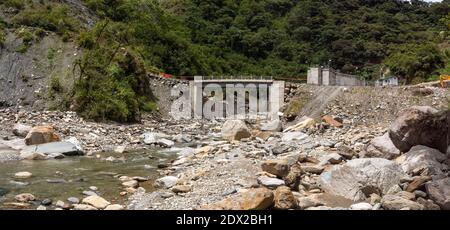 A valle di una presa d'acqua per una centrale idroelettrica in una ripida valle del fiume vicino a Banos nelle Ande ecuadoriane. Foto Stock