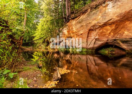 circondato da boschi, la ripida riva del fiume con la calma acqua fluente passato, in cui la bellezza naturale circostante può essere visto come un riferimento Foto Stock
