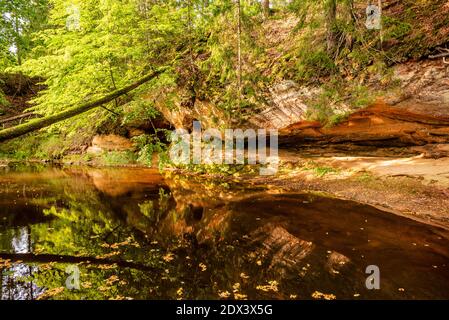 circondato da boschi, la ripida riva del fiume con la calma acqua fluente passato, in cui la bellezza naturale circostante può essere visto come un riferimento Foto Stock