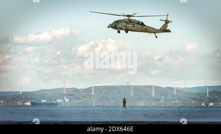 GLI elicotteri MH-60 della marina DEGLI STATI UNITI con i nuotatori di salvataggio praticano al largo della costa vicino a Yokosuka, Giappone. Foto Stock