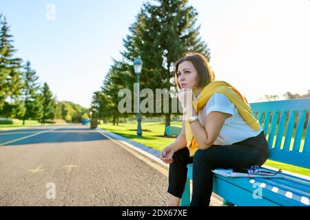 Stanca triste donna matura seduta su panchina nel parco, copia spazio Foto Stock