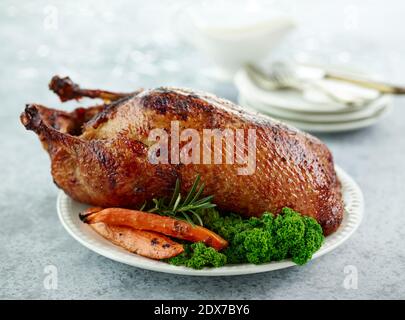arrosto d'anatra appena tostato con verdure su piatto bianco Foto Stock