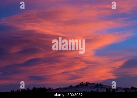 Splendide nuvole lenticolari adornano le Montagne Rocciose su un magnifico tramonto invernale del Colorado. Foto Stock