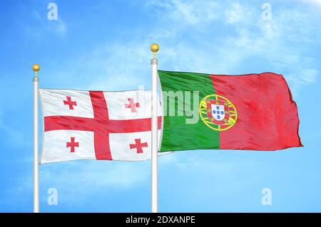 Georgia e Portogallo due bandiere su flagpoli e cielo blu Foto Stock