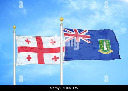 Georgia e Isole Vergini Britanniche due bandiere su flagpoli e. cielo blu Foto Stock