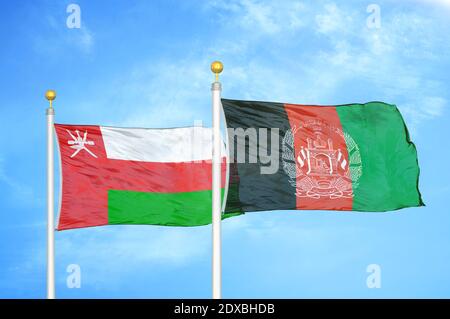 Oman e Afghanistan due bandiere su flagpoli e cielo blu Foto Stock