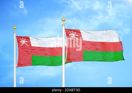 Oman due bandiere su flagpoli e cielo blu Foto Stock