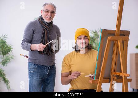 Giovane uomo che prende lezione da pittore esperto Foto Stock