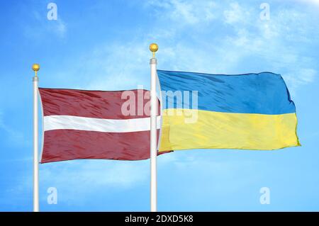 Lettonia e Ucraina due bandiere su paletti e cielo blu Foto Stock