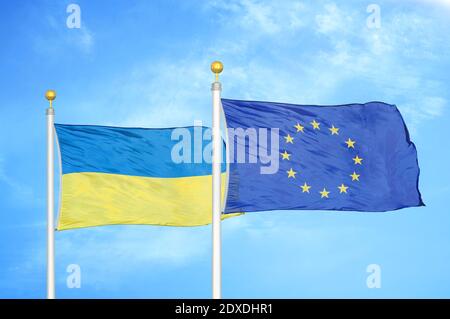 L'Ucraina e l'Unione europea due bandiere su pali e blu cielo Foto Stock
