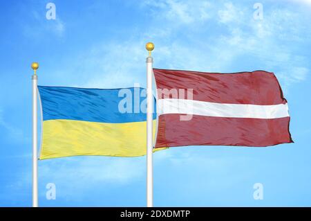 Ucraina e Lettonia due bandiere su paletti e cielo blu Foto Stock