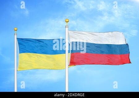 Ucraina e Russia due bandiere su flagpoli e cielo blu Foto Stock