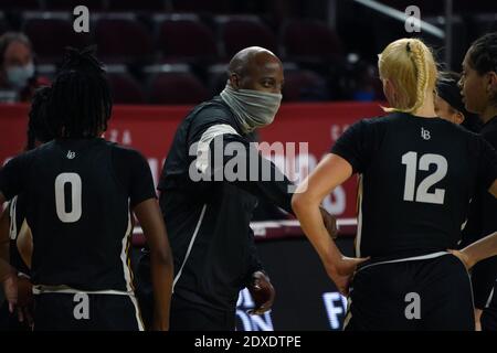 Il capo allenatore di Long Beach Jeff Cammon indossa un volto Maschera in timeout come guardia Ma'Qhi Berry (0) e guardia Kristyna Jeskeova (12) ascoltare durante un NCAA Foto Stock