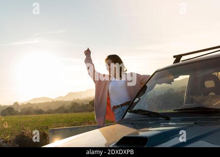 Giovane donna spensierata che ama viaggiare mentre si allontana auto Foto Stock