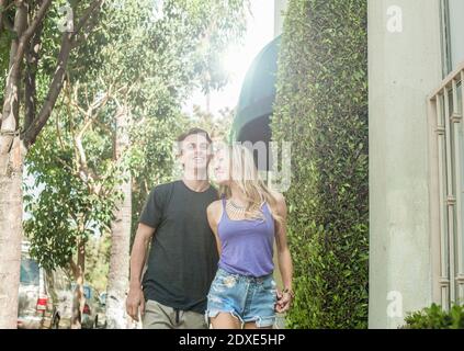 Giovane coppia sorridente che cammina in città Foto Stock