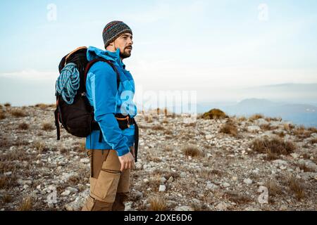 Uomo premuroso che guarda la vista mentre camminando sulla montagna contro cielo Foto Stock