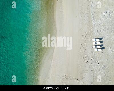 Sedie a sdraio vuote sulla spiaggia tropicale, vista aerea Foto Stock