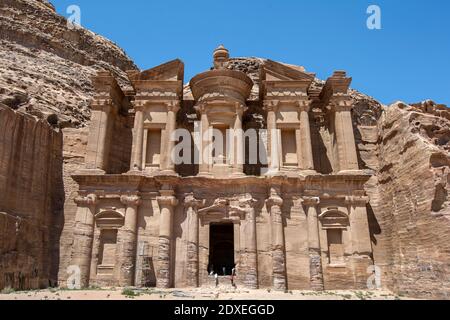 I turisti si arrampicano sull'enorme porta del Monastero nell'antico sito di Petra in Giordania. Fu originariamente costruito come un tempio. Foto Stock